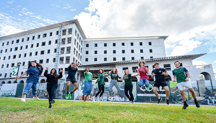 Students Jumping in front of new residence hall