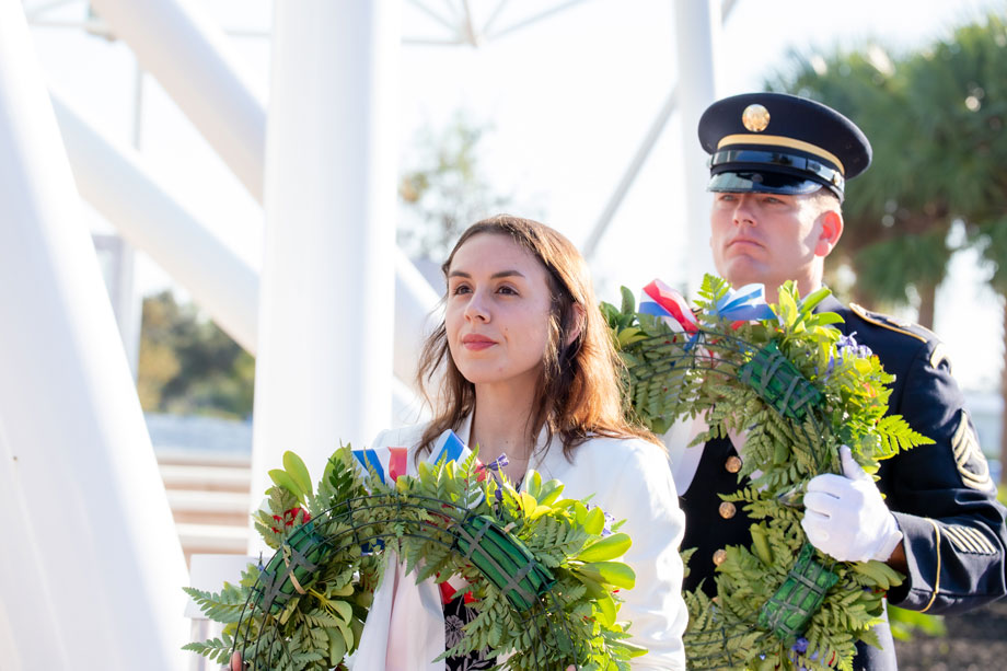 Woman and military person carrying rememberance wreath 