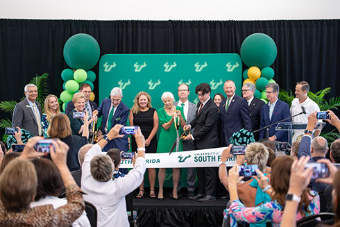 A crowd takes photos of dignitaries cutting the ribbon at the opening ceremony of University of South Florida Sarasota-Manatee's new Campus Student Center and Atala Residence Hall