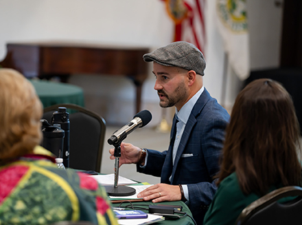 Dane Minnick speaks in front of microphone