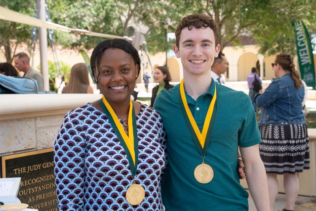 Two students side-by-side wearing honors graduate medals