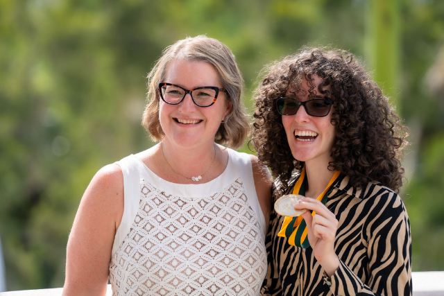 Two students side-by-side wearing honors graduate medals